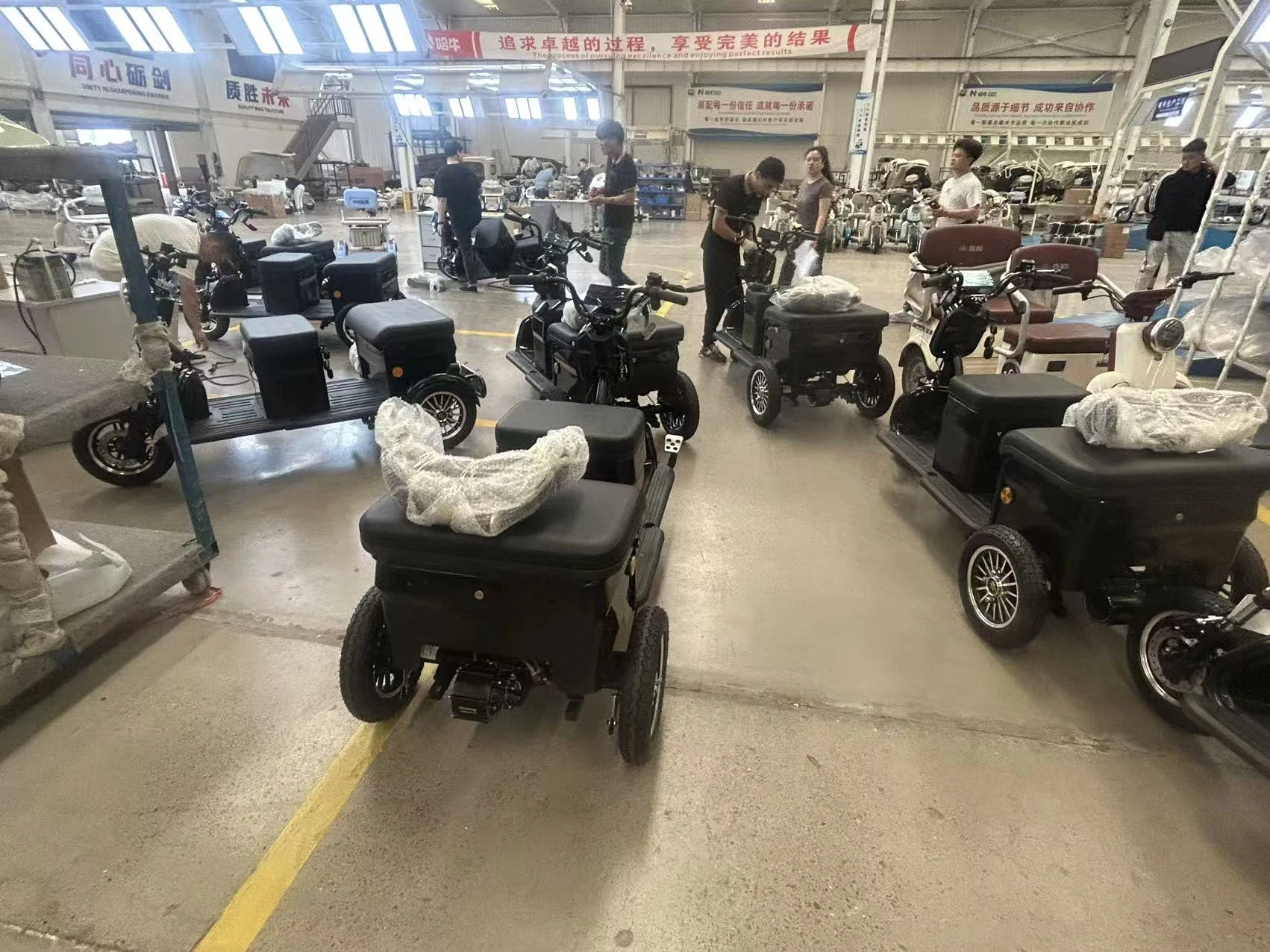 Electric leisure tricycles being assembled in a workshop